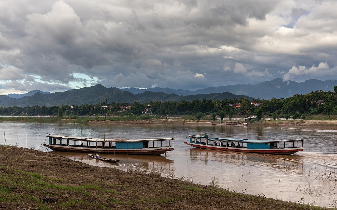 Boats on the Mekong with dark clouds and blue sky